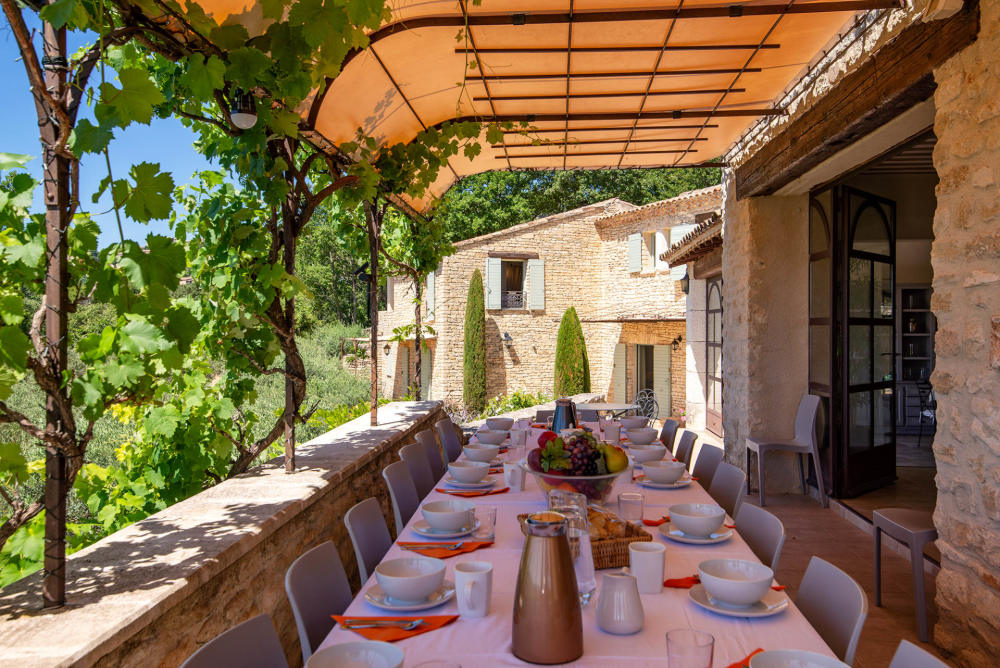 Vine-covered pergola dining terrace at Le Mas de la Route Neuve
